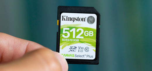 A close-up of a Kingston 512GB SD memory card being held between fingers, highlighting its storage capacity and performance features.